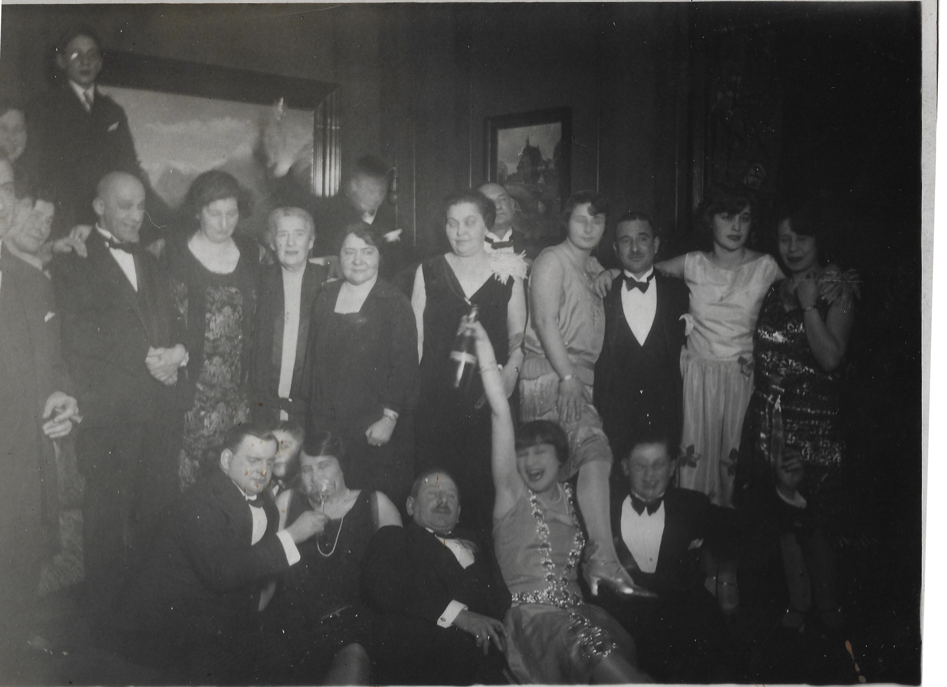 Large group in evening dress gathered closely at a lively party