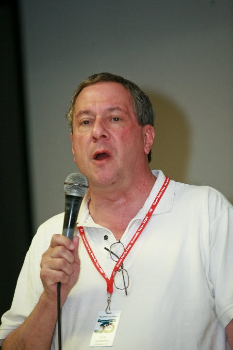 Paul J. Reichenbach speaking into a handheld microphone at a Reform Jewish gathering