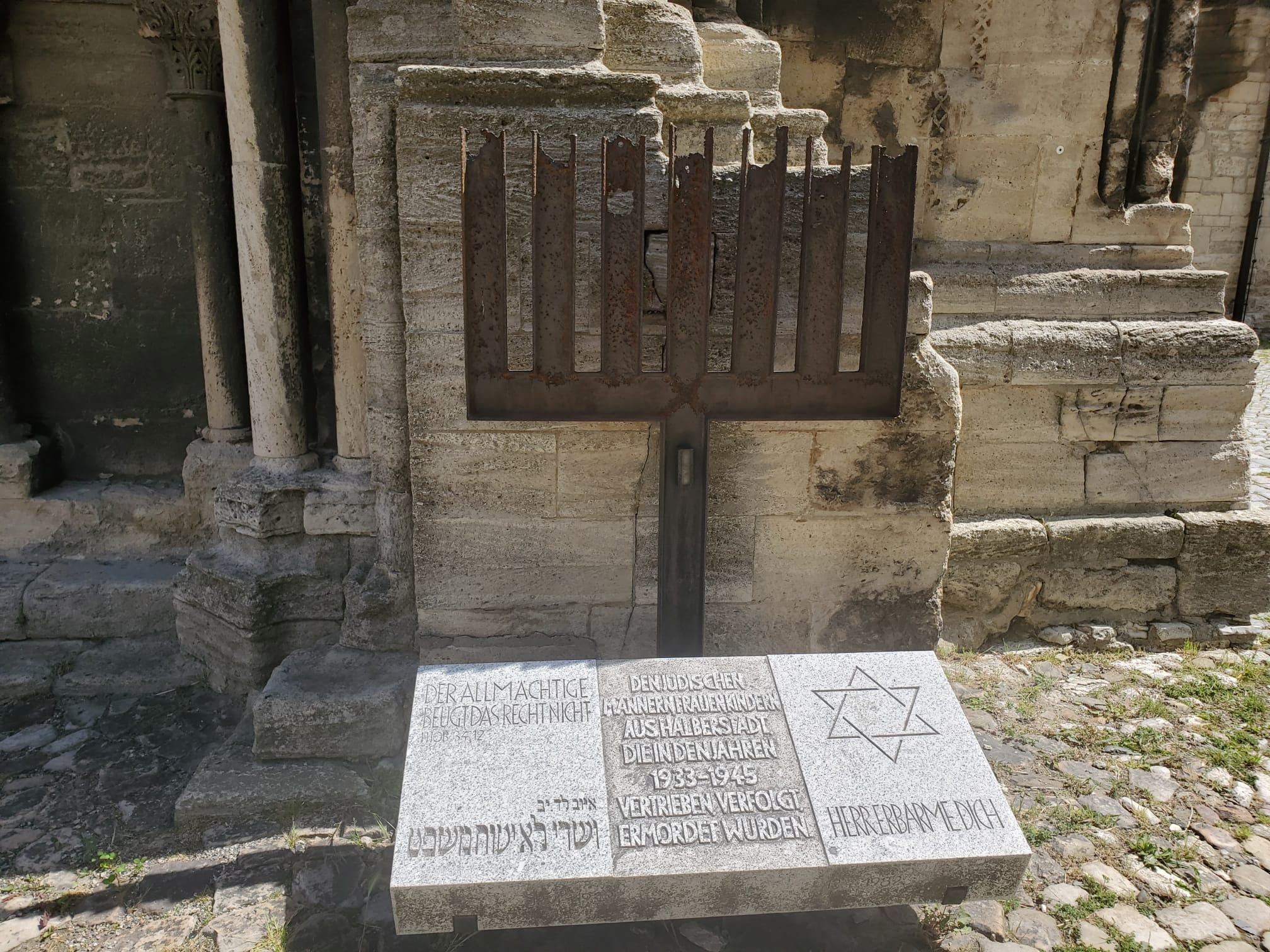 Menorah-shaped memorial and inscribed stone slab beside Halberstadt Cathedral