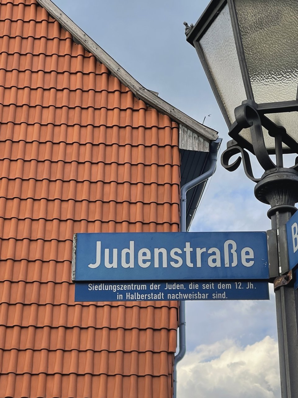 Blue Judenstraße street sign with an explanatory plaque in Halberstadt